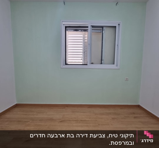 קיר צבוע בצבע ירוק בהיר עם חלון לבן